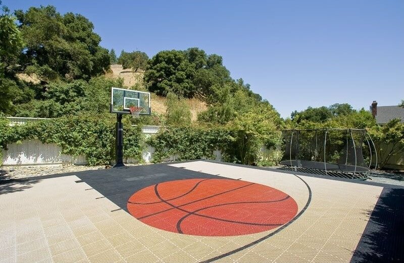 This custom basketball court has a custom tile work basketball decal at the very center. This custom basketball court has a custom tile work basketball decal at the very center.