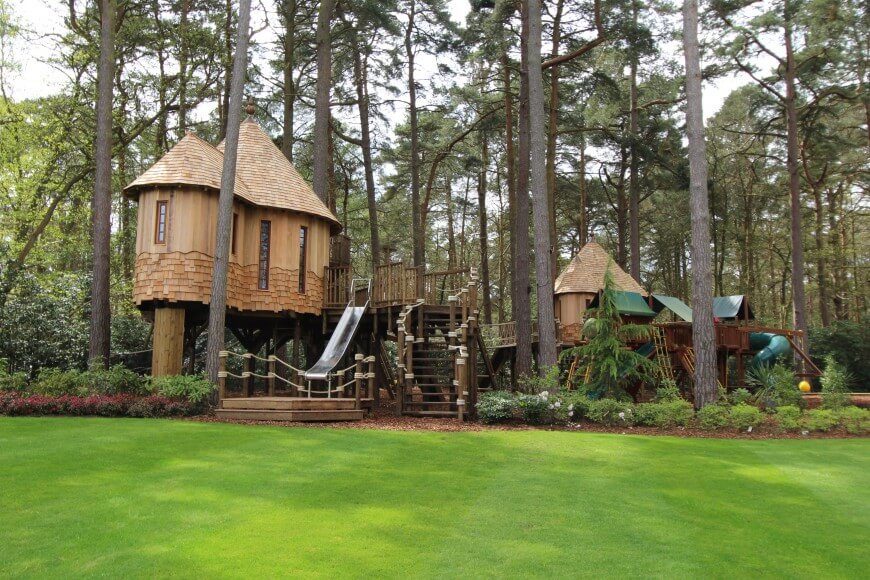 This incredible treehouse is two separate treehouses connected to a massive playset. This incredible treehouse is two separate treehouses connected to a massive playset.