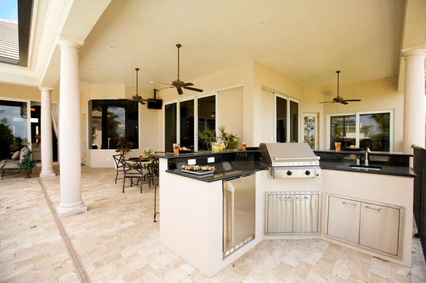 This outdoor kitchen is positioned at the edge of the covered patio and looks back into the dining room, so that the chef may interact with his or her guests. This outdoor kitchen is positioned at the edge of the covered patio and looks back into the dining room, so that the chef may interact with his or her guests.