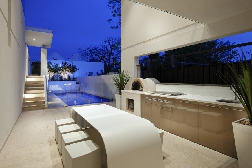 This simple outdoor kitchen embraces a modern design scheme and has a wood-fired oven. This simple outdoor kitchen embraces a modern design scheme and has a wood-fired oven.