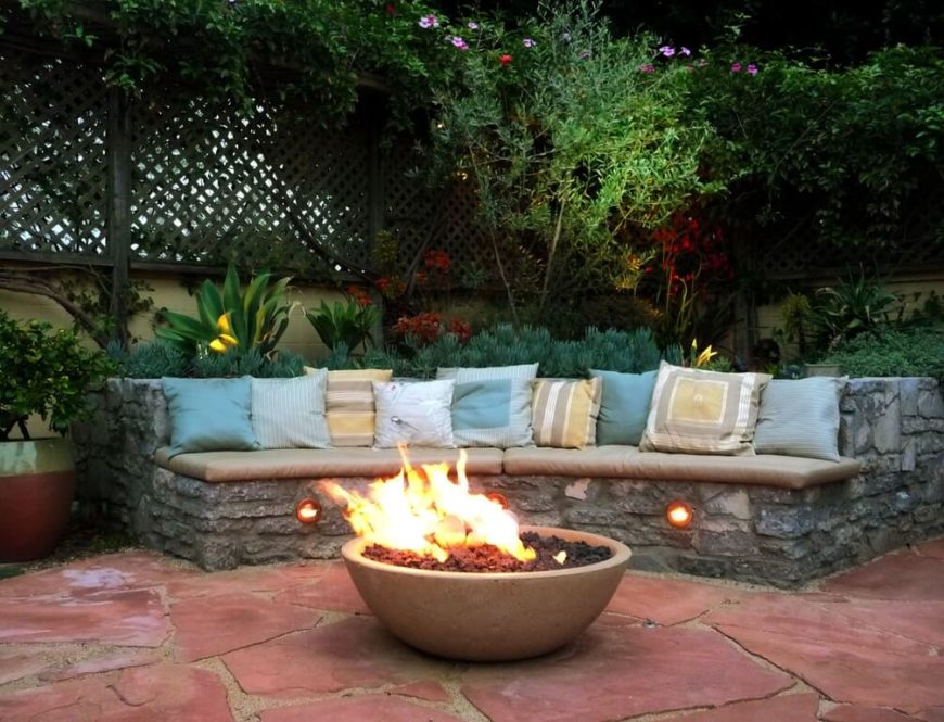This is a unique sort of bench, constructed out of stone and padded with several cushions and many pillows. Lights have been installed in the bottom to illuminate the patio. This is a unique sort of bench, constructed out of stone and padded with several cushions and many pillows. Lights have been installed in the bottom to illuminate the patio.