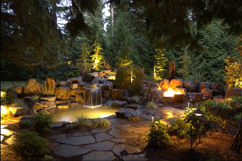 This is lighting done right. Aside from the bonfire in the fire pit, other lights are installed along the pathway, in the pond, and even above the small waterfall. This is lighting done right. Aside from the bonfire in the fire pit, other lights are installed along the pathway, in the pond, and even above the small waterfall.