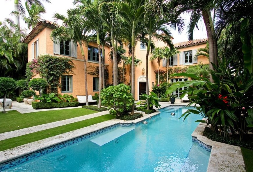 Tall palms frame the walkway that leads to the enormous swimming pool in the backyard of this enormous, classy home. Tall palms frame the walkway that leads to the enormous swimming pool in the backyard of this enormous, classy home.