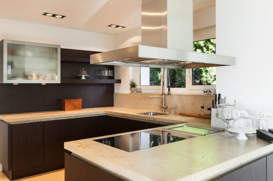 Subtle concrete countertops in a light patina. The countertops are punctuated by a ceramic cook top and an industrial style stainless steel sink. Subtle concrete countertops in a light patina. The countertops are punctuated by a ceramic cook top and an industrial style stainless steel sink.