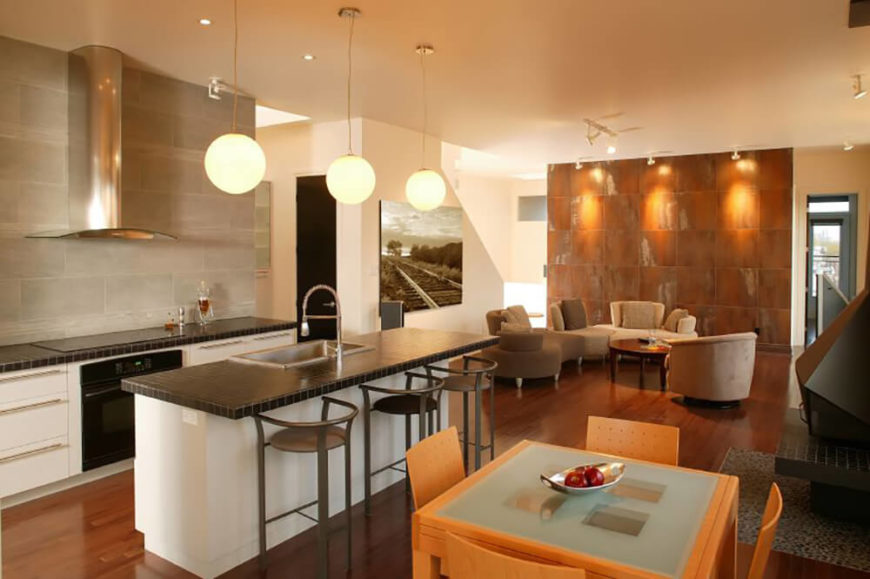 A kitchen with countertops done in small format black tiles, which contrast with the large format gray tile backsplash. A kitchen with countertops done in small format black tiles, which contrast with the large format gray tile backsplash.