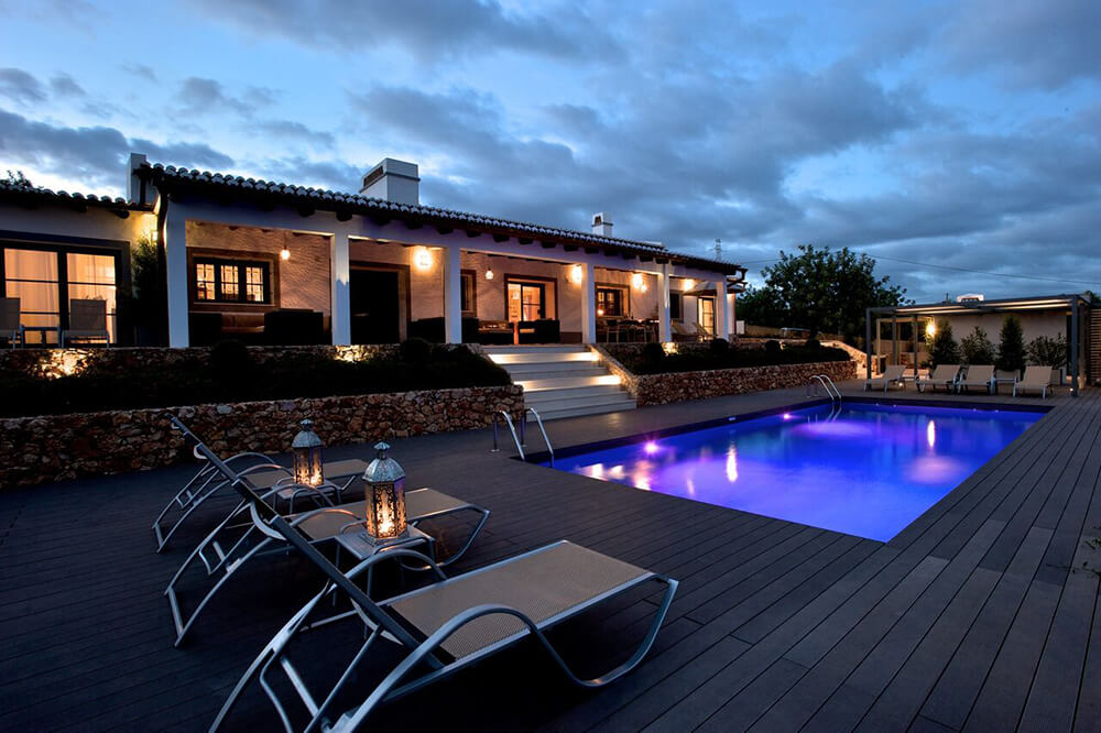 This luxurious property has a regular pool in the backyard with several loungers.