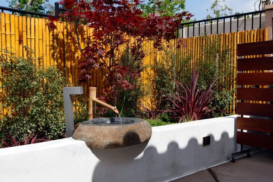 A bamboo privacy fence mounted on a wrought iron fence. A bamboo privacy fence mounted on a wrought iron fence.