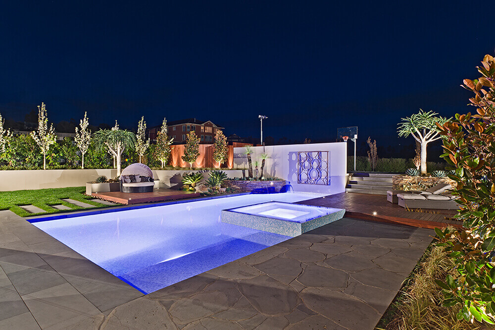 This custom swimming pool features an underwater lighting for additional style.