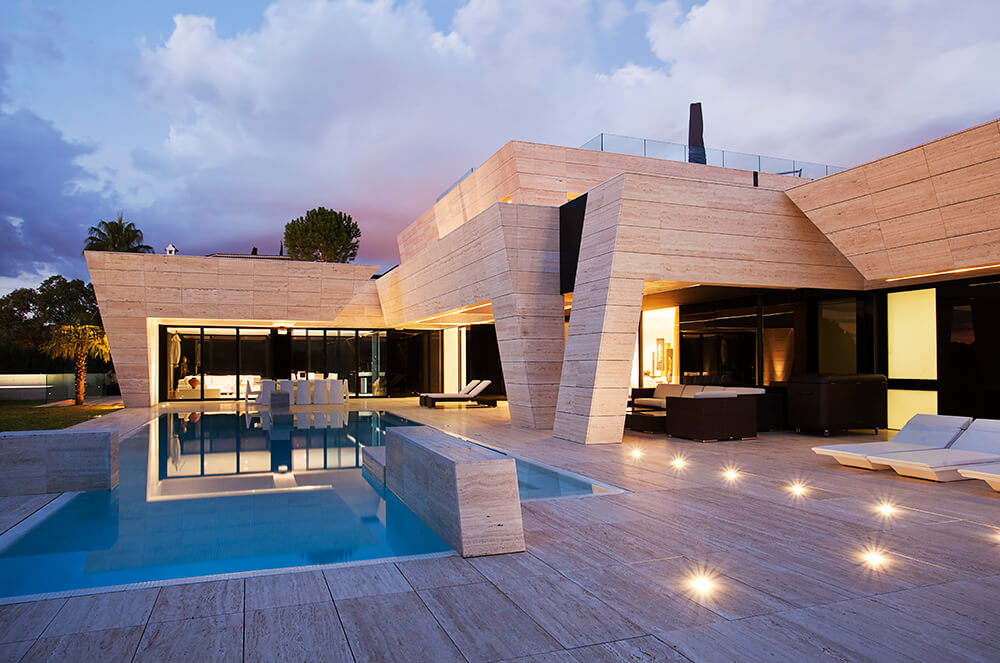 Stylish and modern home featuring a custom infinity pool surrounded by the home's deck.