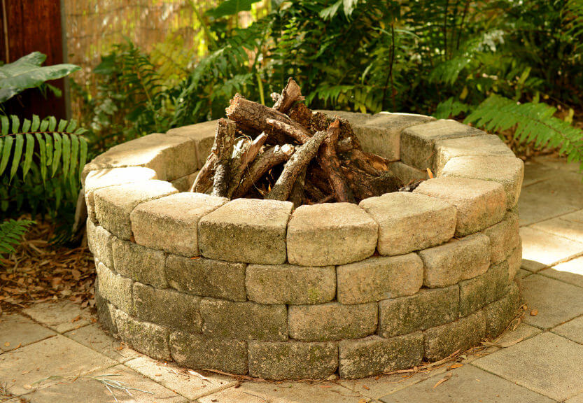 Massive round brick wood-burning fire pit placed on large patio. Massive round brick wood-burning fire pit placed on large patio.