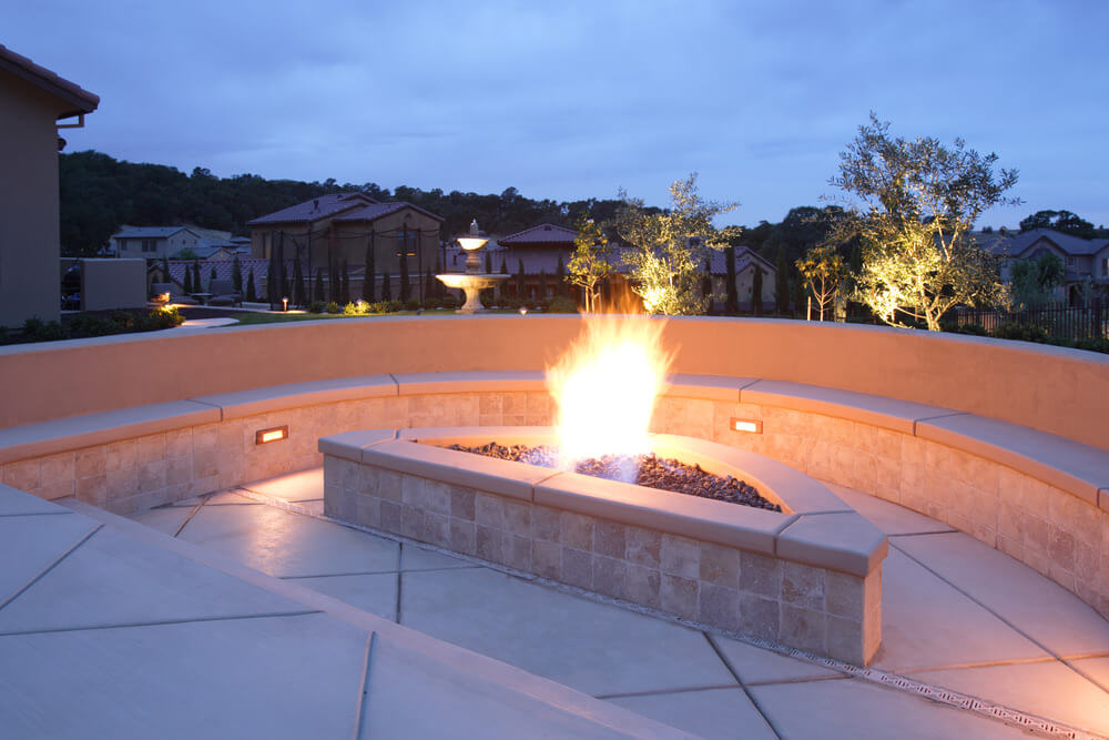 Luxurious multilevel patio with built-in custom gas fuelled by her pit surrounded by built-in bench seating. Luxurious multilevel patio with built-in custom gas fuelled by her pit surrounded by built-in bench seating.