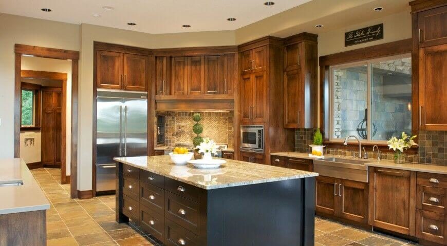 The black island isn't something you'll see in purely Craftsman kitchens, but it is a great contrast piece to the rest of this starkly Craftsman design that includes lots of trim work, simple windows, and natural stone tile. The black island isn't something you'll see in purely Craftsman kitchens, but it is a great contrast piece to the rest of this starkly Craftsman design that includes lots of trim work, simple windows, and natural stone tile.