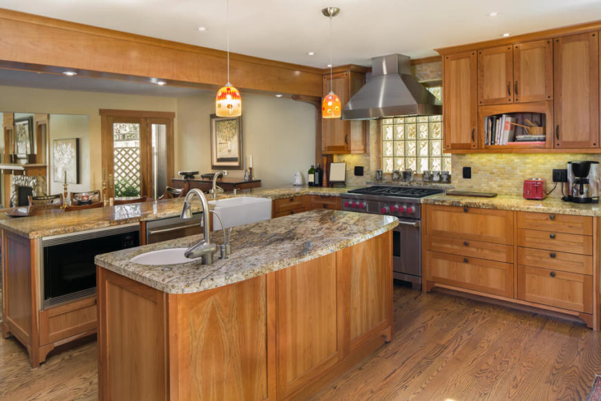 The soft, natural materials and colors of this kitchen are broken by two small Tiffany style pendant lights above the lengthy center island. Oak flooring contrasts and yet meshes perfectly with the lighter grained wood of the cabinets. The soft, natural materials and colors of this kitchen are broken by two small Tiffany style pendant lights above the lengthy center island. Oak flooring contrasts and yet meshes perfectly with the lighter grained wood of the cabinets.