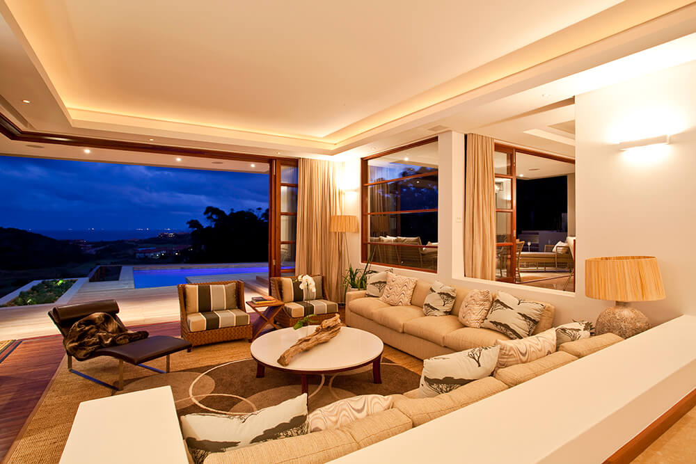 A large formal living space with a nice set of seats under the luxurious tray ceiling.