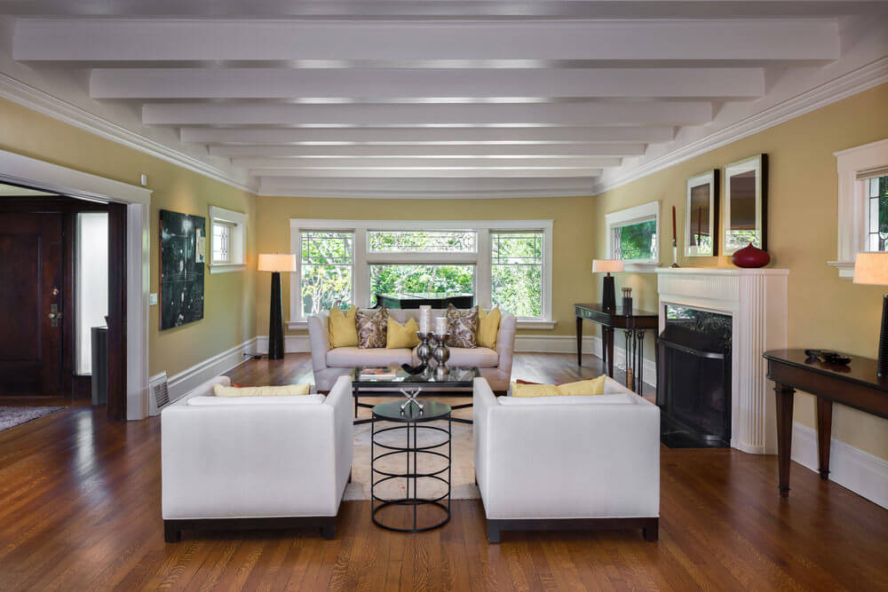 Make your living room calming and inviting by using lighter shades of brown or even yellow for your walls and accentuated with light grey fixtures and furnishings. With this color scheme, it will allow your living room to glow more naturally and accentuate its size. Large living room featuring hardwood flooring and cozy seats. It has a fireplace as well.