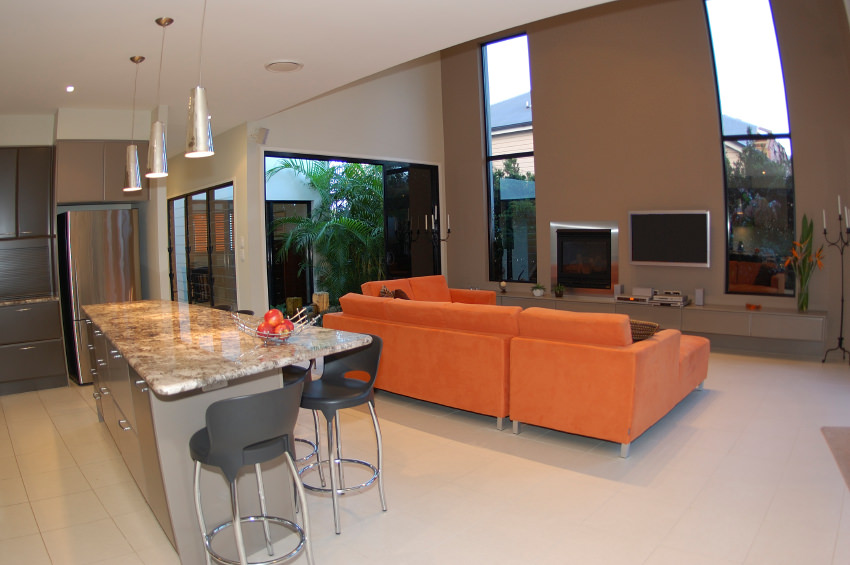 This orange sofa set sits comfortably in an open concept interior right next to the kitchen, where there's a matching tray of fruit. Over toward the windows are orange bird of paradise flowers. This orange sofa set sits comfortably in an open concept interior right next to the kitchen, where there's a matching tray of fruit. Over toward the windows are orange bird of paradise flowers.