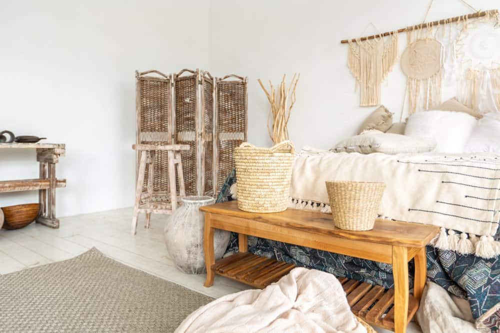 Spacious primary bedroom featuring a large elegant bed set along with some rustic furniture and design surrounded by white walls and ceiling.