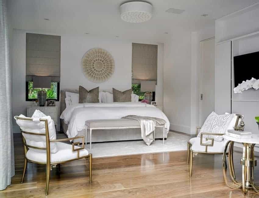 A glamorous Scandinavian-Style primary bedroom with a luxurious bed set on the classy white rug covering the hardwood flooring.