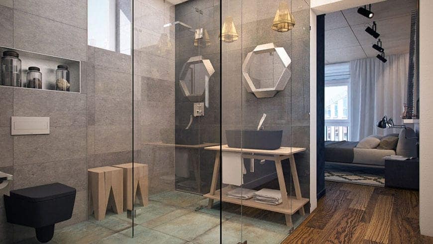 The hardwood flooring from the bedroom leads to this bathroom with a glass enclosure. Within this glass enclosure is the sink with a wooden table and black basin matching the black bowl and wooden stools of the shower area.