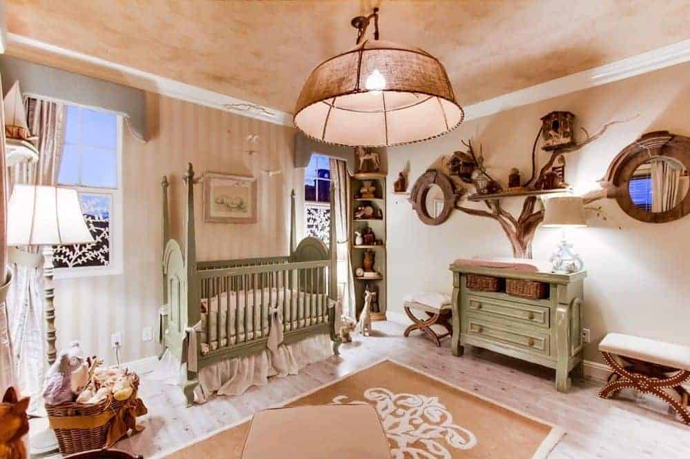 Warm nursery illuminated by an oversized dome pendant that hung over the beige printed rug on hardwood flooring. It has green four poster crib and cabinet designed as a tree along with a floating shelf and mirrors.