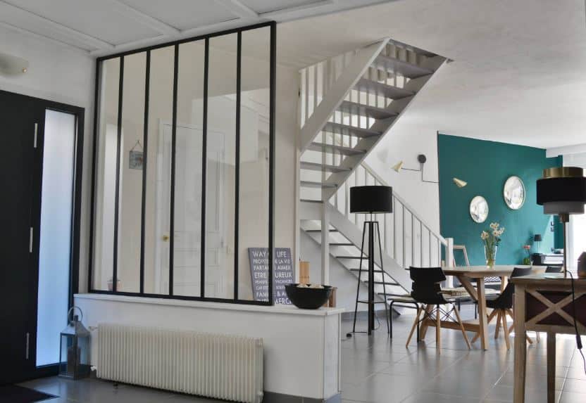 The black main door has frosted glass sight lights that matches with the glass wall that separates the foyer from the rest of the house that has the same flooring tiles and white ceiling. On the side of the entrance is a heater for a warm welcome.