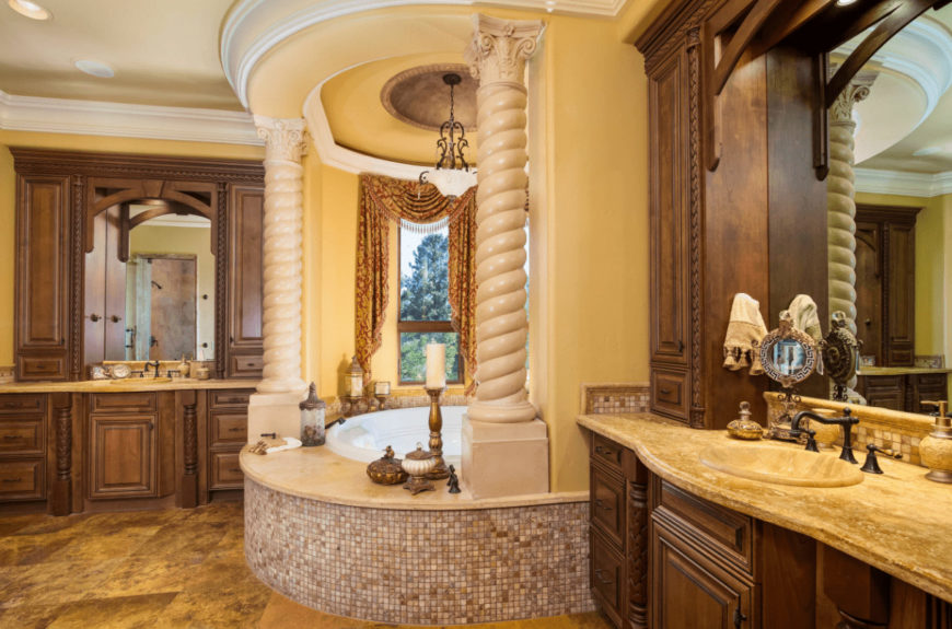 Classy primary bathroom with alcove tub and wooden sink vanities topped with limestone counters that complement the tiled flooring.