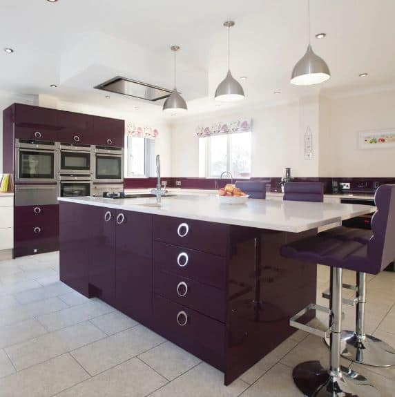 The dark purple hue that dominates this modern kitchen is almost nearing the black palette. This is a nice contrast to the white countertops, the light gray flooring tiles, light beige walls and white ceiling as well as the stainless steel appliances.