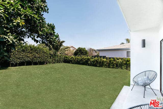 This is a beautiful lawn of well-manicured grass perfect for those lazy afternoons and provides a safe enclosed space for the kids and pets to play around under the sun. This lawn is surrounded by thick shrubbery, tall trees and wooden fencing and can be enjoyed also from the couple of outdoor chairs under the shade of the house.