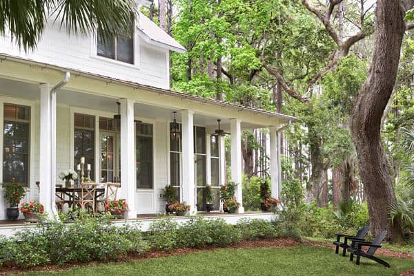This is a lovely area of this house that gives a sense of isolation perfect for an afternoon just sitting on a lawn chair reading with the shades of the tall trees and a view of colorful flowering shrubberies that complement the white exteriors of the home.